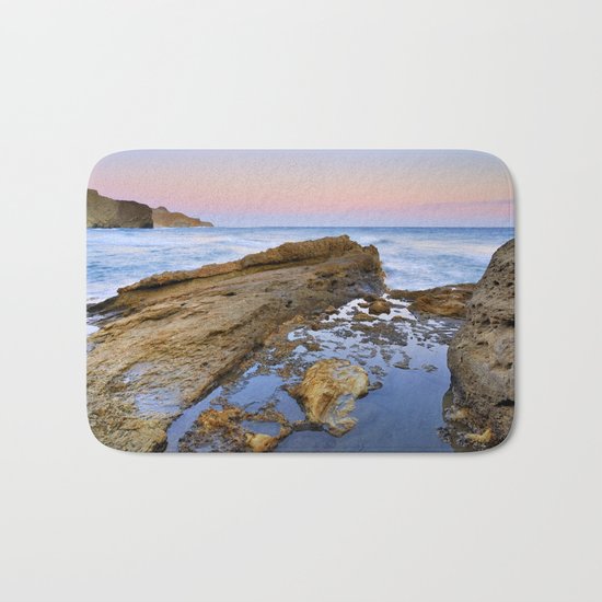"Volcanic sea at pink sunset" Bath Mat