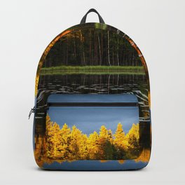 Mirrored autumn lake with golden foliage reflection as sun sets alpine color photograph / photography Backpack