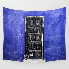 Black worn out door on blue wall Wall Tapestry