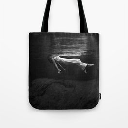 Underwater view of a woman floating in water Tote Bag