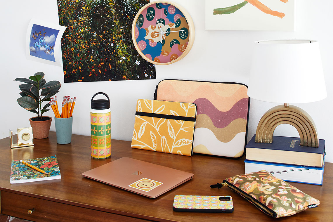 Desk featuring water bottles, laptop cases, notepads, wall art and more.