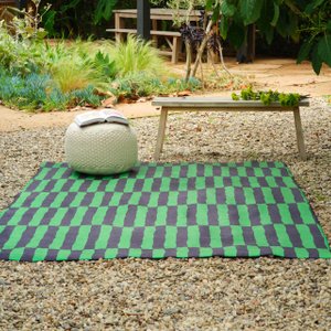 green and black outdoor rug in a backyard