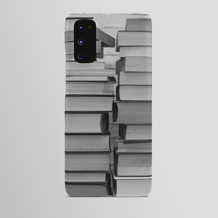 Black and white image of some books stacked on a shelf Android Case