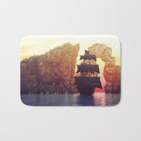 A pirate ship off an island at a sunset Bath Mat