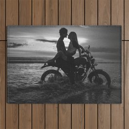 The motorcyclists; lovers at sunset on vintage motorcycle coastal beach romantic portrait black and white photograph - photography - photographs by Yuliya Kirayonak Outdoor Rug