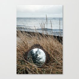 Vintage mirror on seaside reflects forest and sky. Canvas Print