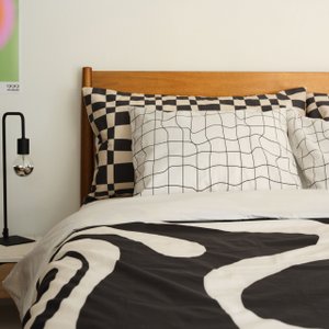 bed with black and white warped and checked bedding