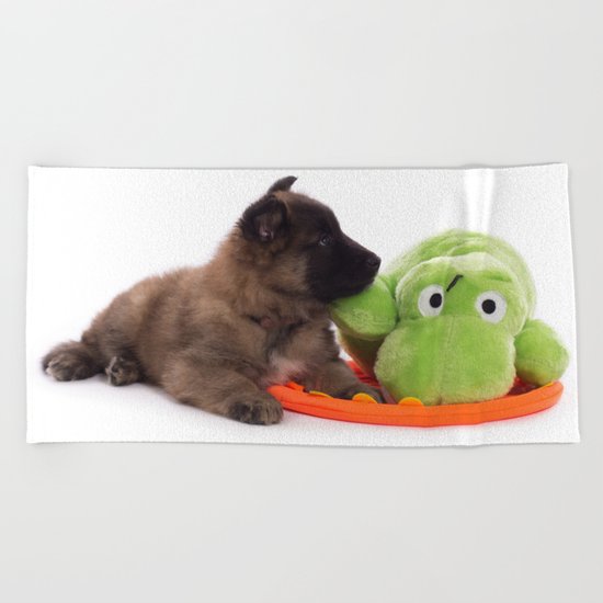 Puppy cuddling green toy Beach Towel