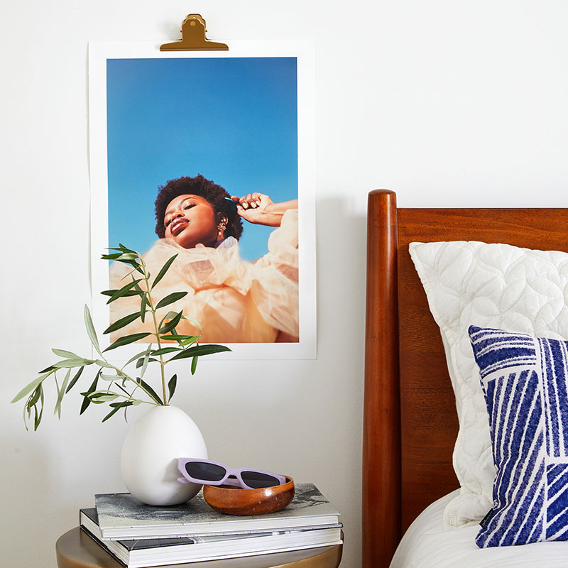 art print hanging next to a bed