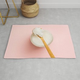 Spoon with coconut oil on pink background, flat lay Rug