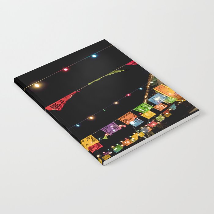 Beautiful Rainbow Colored Paper Flags and Lights Hang across a Day of the Dead Evening Celebration Notebook