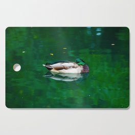 Beautiful elegant duck swimming in green lake water Cutting Board