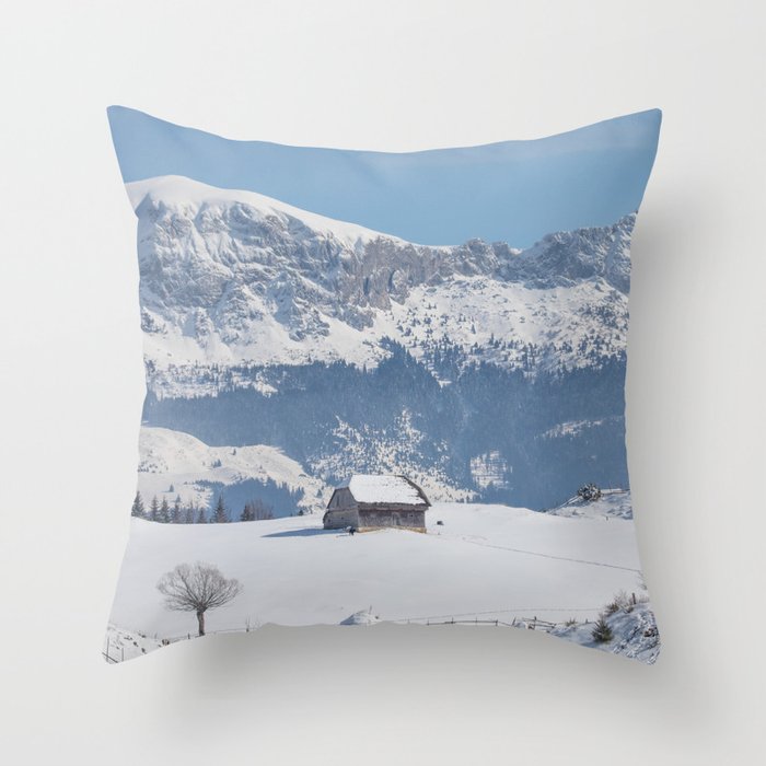 Winter landscape with an old house and Bucegi mountains in the background Throw Pillow