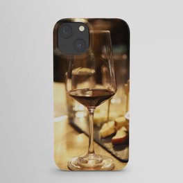 Glass of red wine on a table iPhone Case