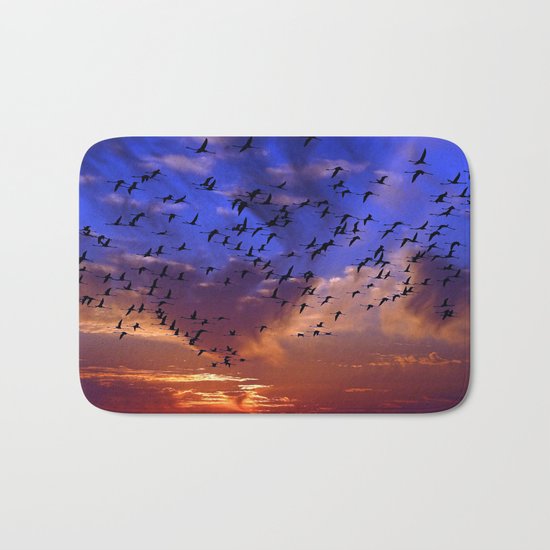 Flight of flamingos at sunset Bath Mat