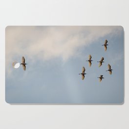 Egrets flying overhead. Cutting Board