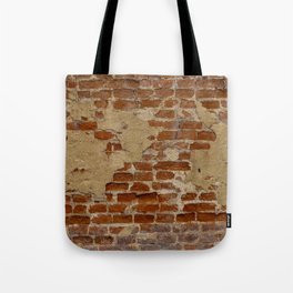 Worn out brick wall background with old plaster stains Tote Bag