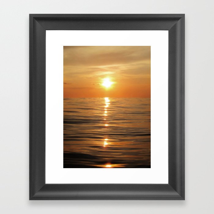 Sun setting over calm waters Framed Art Print