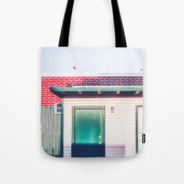 green wood building with brick building in the city Tote Bag