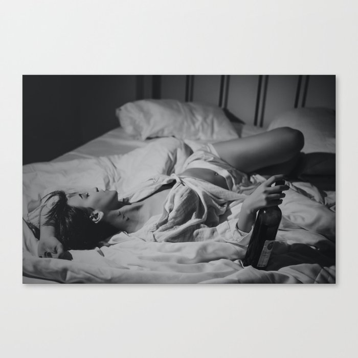 Raise your glass; young female in bed with a bottle of wine black and white portrait photograph Canvas Print