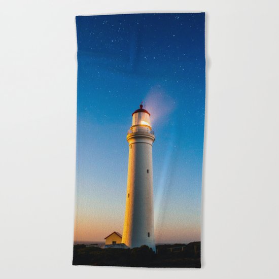 Lighthouse at night Beach Towel