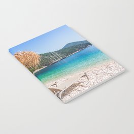 Kefalonia, Greece. Beach chair and umbrella at the Antisamos beach. Notebook