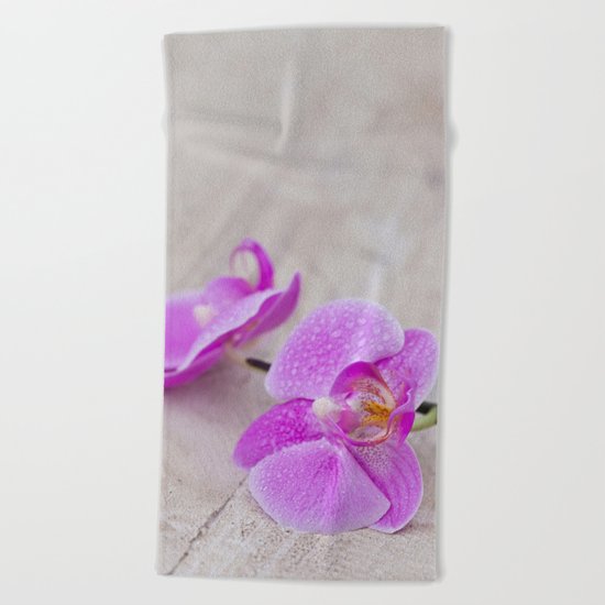 pink orchid flower close up water drops Beach Towel