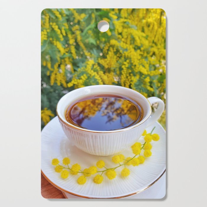 Mimosa perfumed cup of tea, spring in Italy, March. Cutting Board