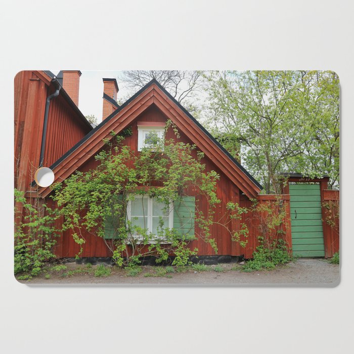 Cute red wood Swedish house in the green  Cutting Board