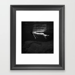 Underwater view of a woman floating in water Framed Art Print