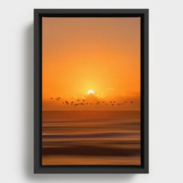 Birds flying across a sunset at the beach Framed Canvas