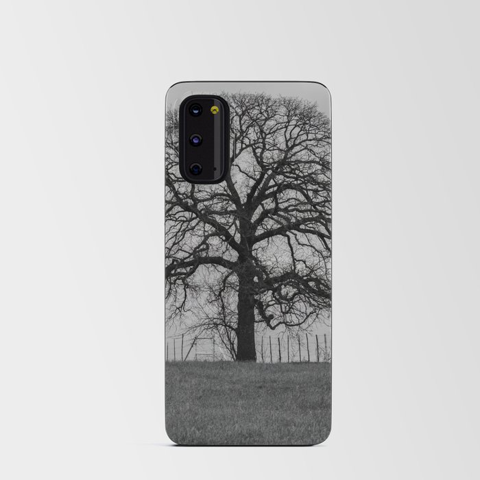 Spooky leafless tree on fence line silhouetted on the horizon against a gloomy sky Android Card Case
