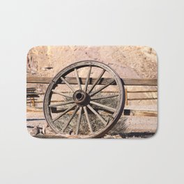 Old wagon wheel against a fence Bath Mat