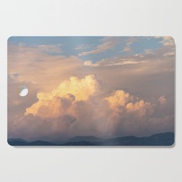Cloudy orange sunset over the mountains Cutting Board