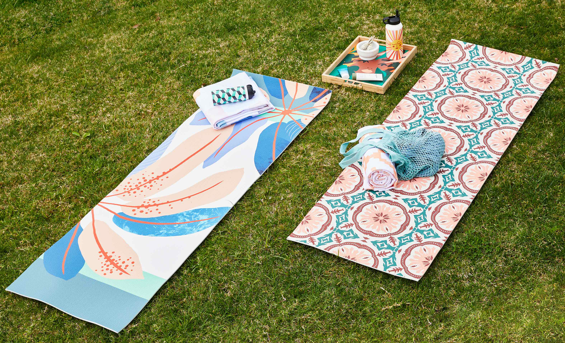 pastel floral yoga mats on a grassy lawn