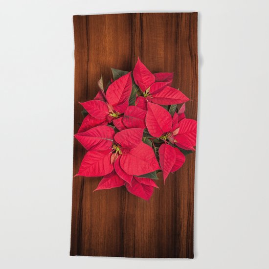 Red Christmas flower on brown wood Beach Towel