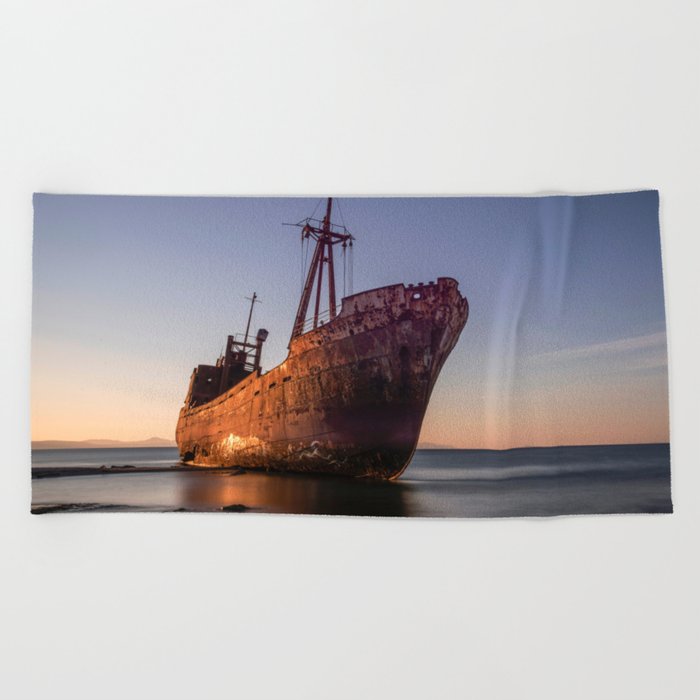 An old ship wreck on the beach Beach Towel