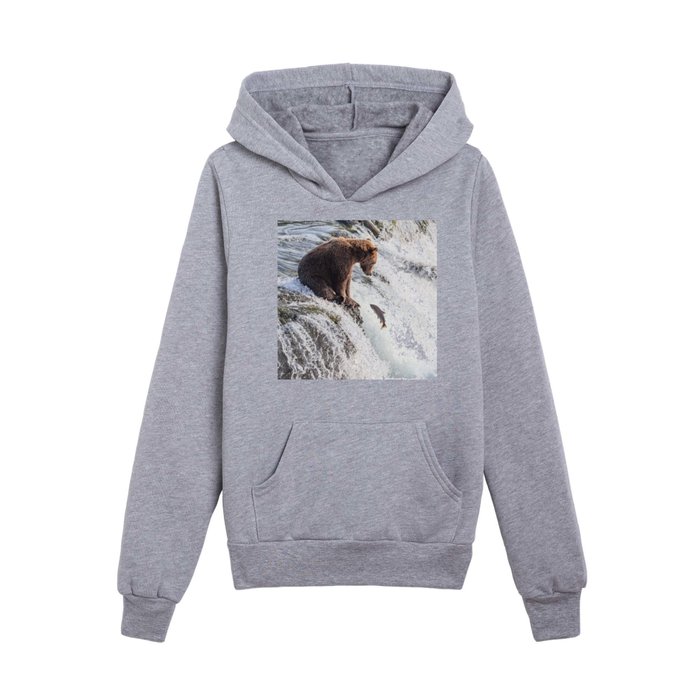 Young grizzly bear sits at waterfall Kids Pullover Hoodie