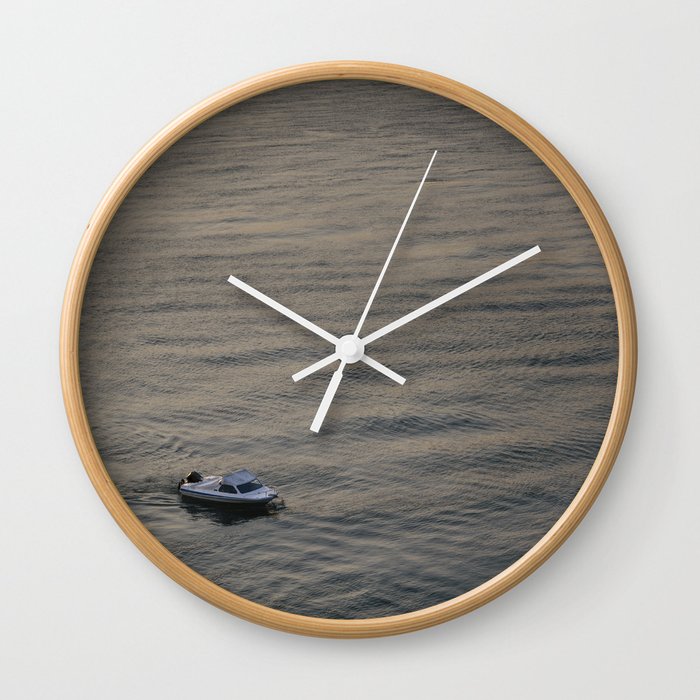 Small boat anchored in the river Wall Clock