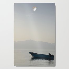 boat in middle of sea with mountains behind it in egypt  Cutting Board