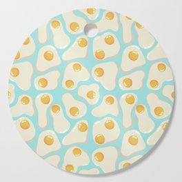 Fried Eggs on blue background Cutting Board