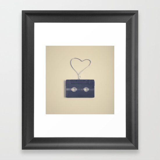 Retro black music cassette and heart shaped tape on beige background Framed Art Print