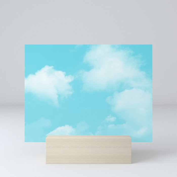 Cute puffy small white clouds on a sunny aqua blue sky Mini Art Print