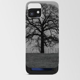 Spooky leafless tree on fence line silhouetted on the horizon against a gloomy sky iPhone Card Case