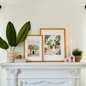 pair of framed prints on a mantel