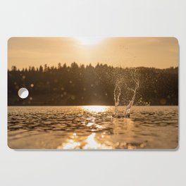 Water splash against sunset Cutting Board