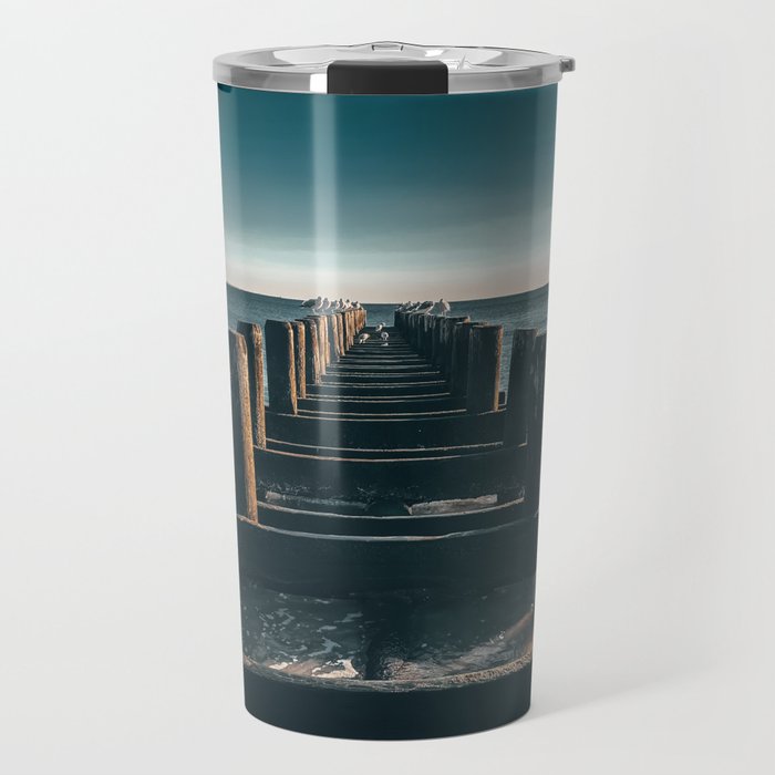 Wooden piers and seagulls on a peaceful morning with calm ocean Travel Mug