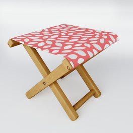 White Abstract Spring Seeds on a Red Color Folding Stool