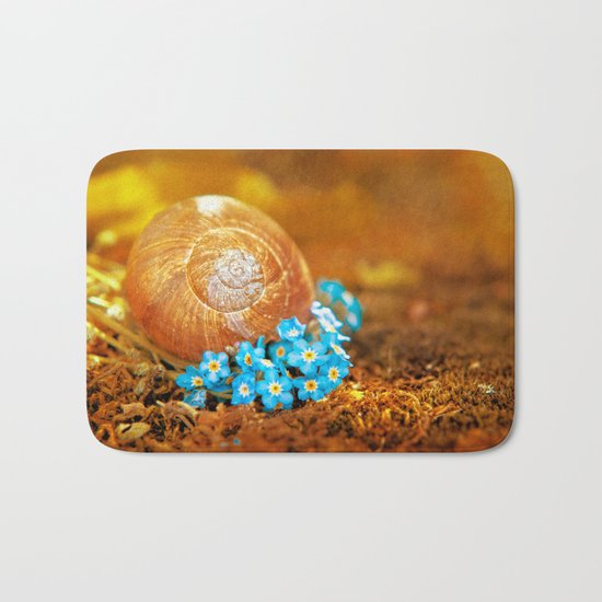 Golden snail house in a bed of forget-me-not Bath Mat