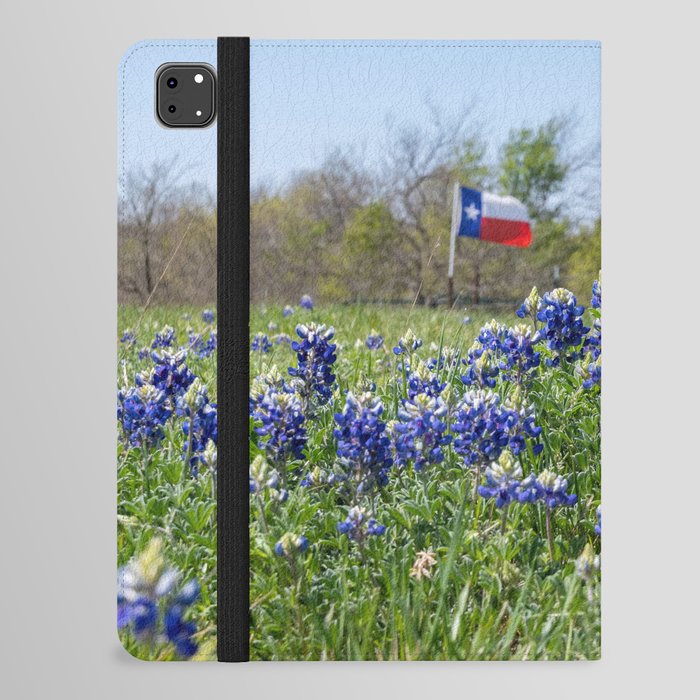 Bluebonnet flowers blooming by road with Texas flag in background iPad Folio Case